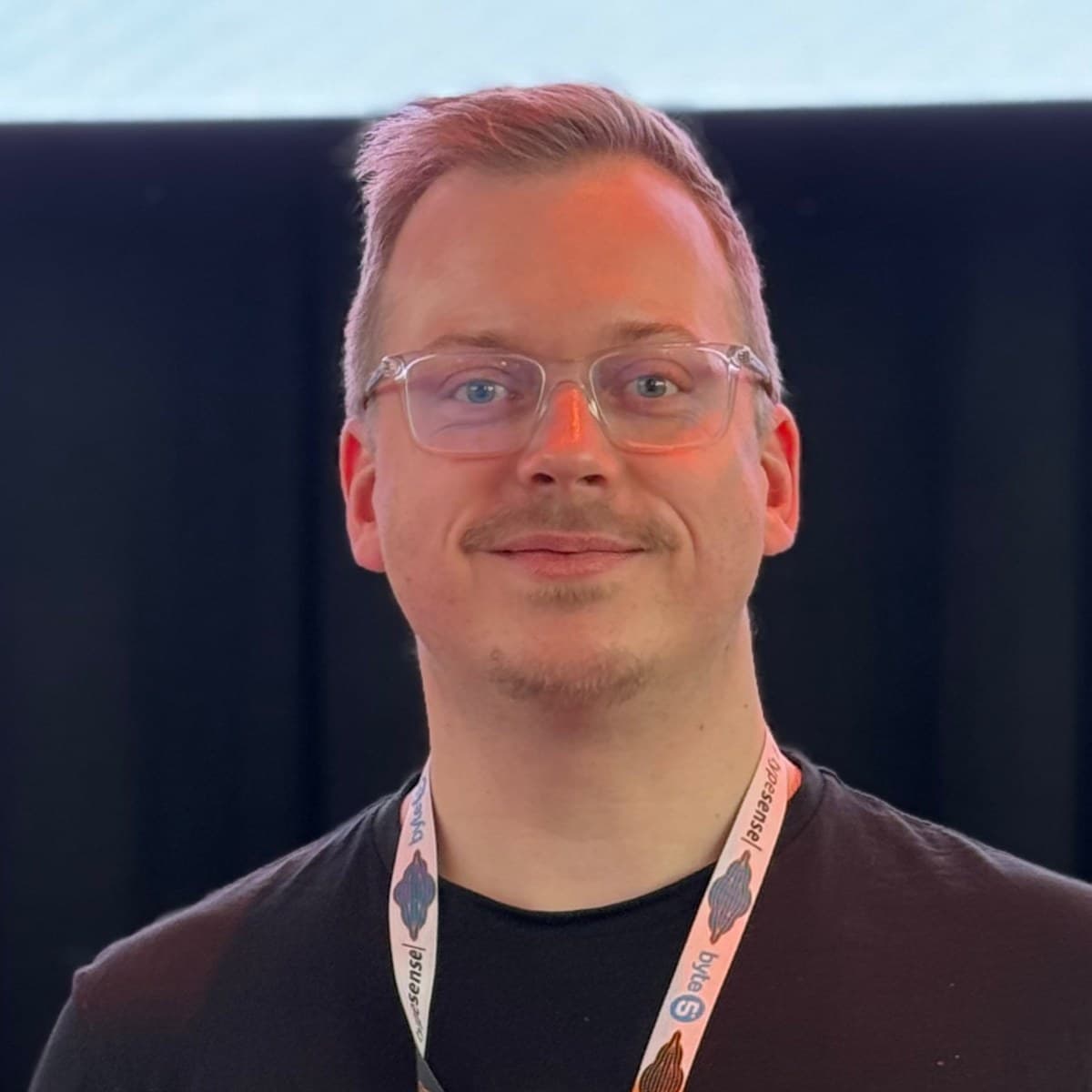 Dennis Petersmann wearing a conference lanyard